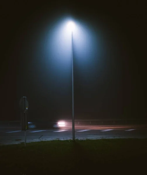 在夜间被街上抓拍到的一根路灯柱的垂直截图 — 图库照片