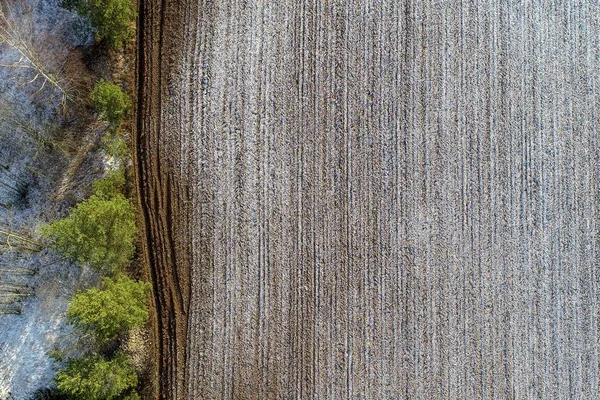 Overhead shot of an agricultural field with drops of snow in the countryside — Stock Photo, Image