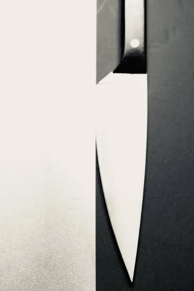 Tiro Vertical Escala Cinza Uma Faca Uma Superfície Preta Branca — Fotografia de Stock