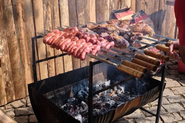 Salsichas deliciosas e carne sendo cozida em carvão em um quintal — Fotografia de Stock