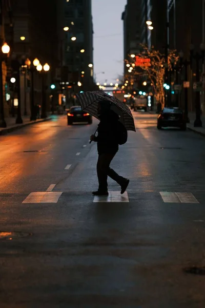 우산으로 길을 건넌 사람의 수직 사진 — 스톡 사진