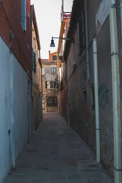 Tiro vertical de un estrecho sendero en medio de edificios en Italia Venecia — Foto de Stock