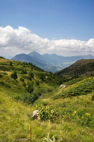Uma Paisagem Colinas Cobertas Vegetação Com Montanhas Rochosas Sob Céu — Fotografia de Stock