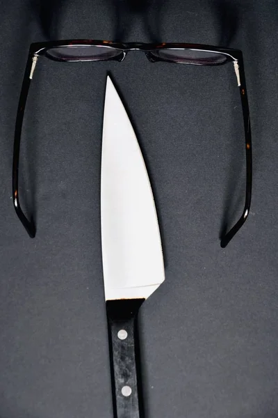 Colpo Verticale Angolo Alto Coltello Affilato Accanto Occhiali Marroni Una — Foto Stock