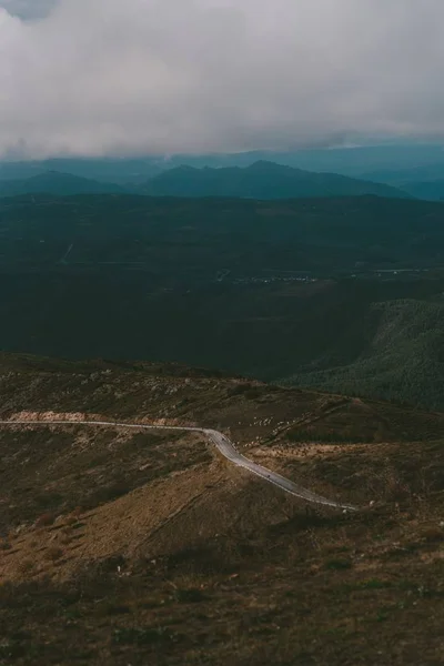 Vertikalt skott av en väg upp till berget under en molnig himmel — Stockfoto