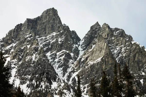 Una Gama Montañas Rocosas Cubiertas Nieve Bajo Cielo Brillante — Foto de Stock