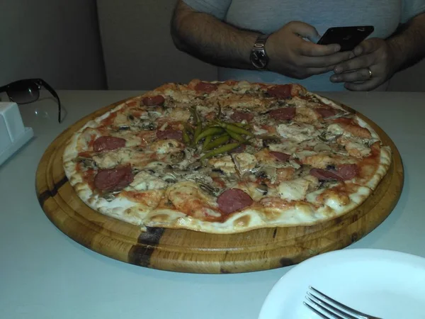 Tiro de alta ângulo de uma deliciosa pizza em uma mesa branca em um restaurante — Fotografia de Stock