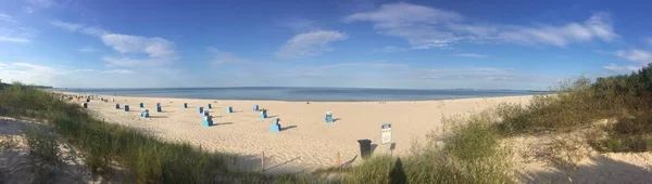 Tiro panorâmico de uma praia rochosa arenosa em um dia ensolarado brilhante — Fotografia de Stock