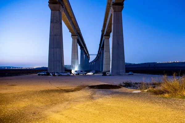Бетонный Мост Окружении Автомобилей Огней Холмами Заднем Плане Течение Вечера — стоковое фото
