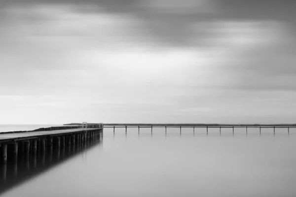 Greyscale Shot Wooden Pier Sea Beautiful Cloudy Sky — 스톡 사진