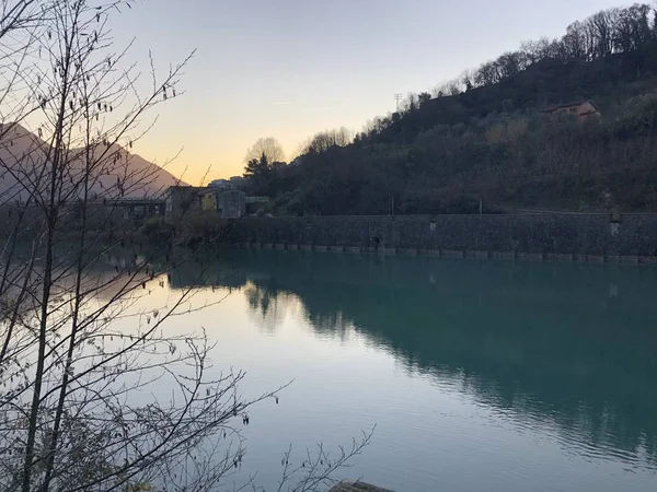 イタリアの日没時に緑に覆われた丘に囲まれたSerchio川 — ストック写真