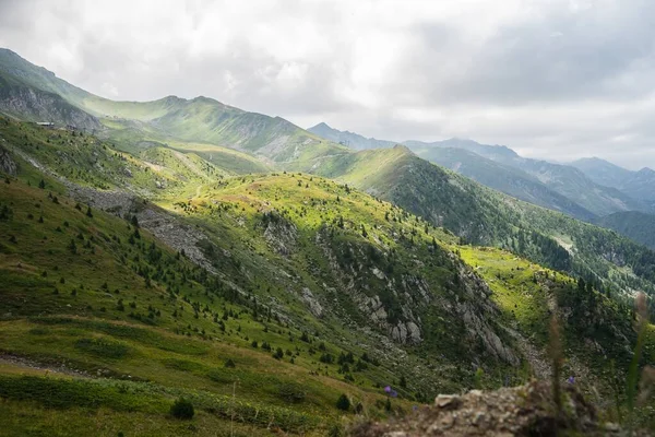 Uma Paisagem Colinas Cobertas Vegetação Com Montanhas Rochosas Sob Céu — Fotografia de Stock