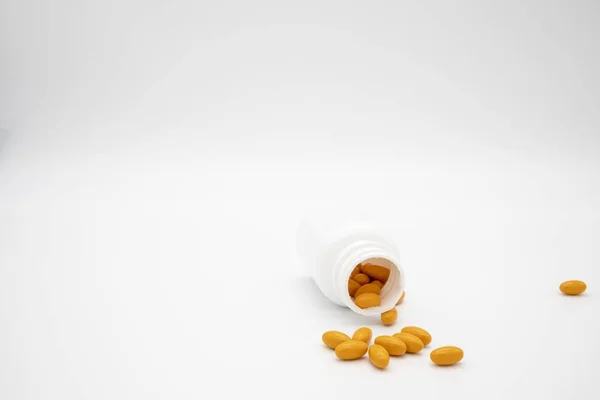 Orange Pills Spilling Out White Pill Bottle White Background — 스톡 사진