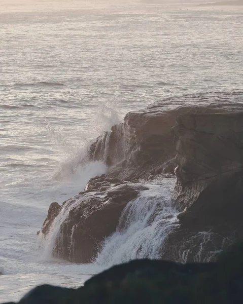 Вертикальный снимок морских волн, ударяющихся о скалу — стоковое фото