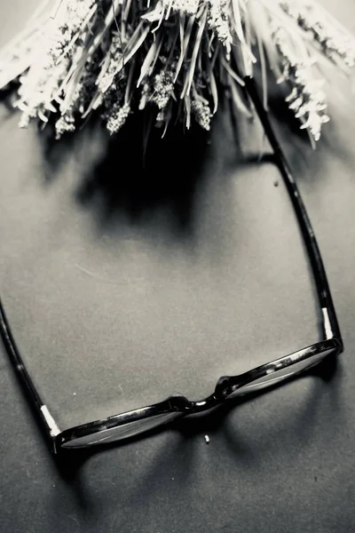 Een Verticaal Grijs Schaalbeeld Van Een Bril Bloemen Een Grijs — Stockfoto