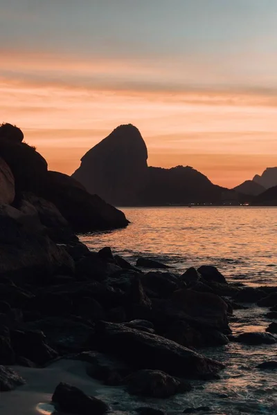 리우데자네이루에서 일몰 광경을 배경으로 바다 근처의 아름다운 암석층 — 스톡 사진
