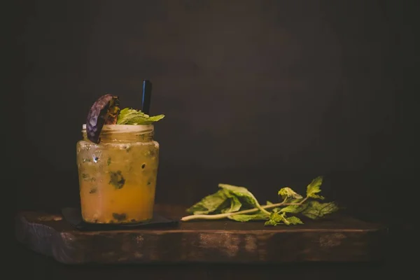 Помаранчевий коктейль з м'ятним листом на дерев'яному підносі — стокове фото