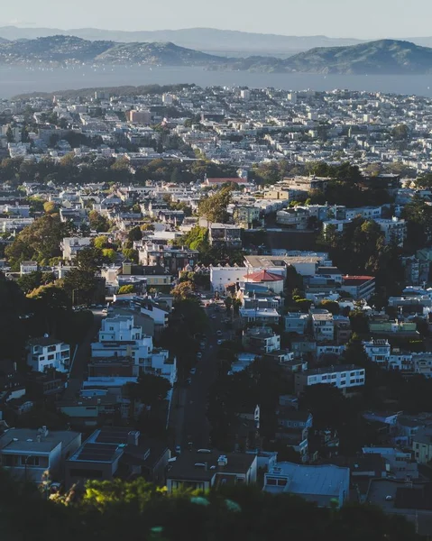 Vertical shot of city buildings with mountains in the distance — Stock Photo, Image