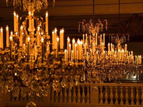 Hermoso candelabro con las luces encendidas en un edificio con balcón con columnas. — Foto de Stock