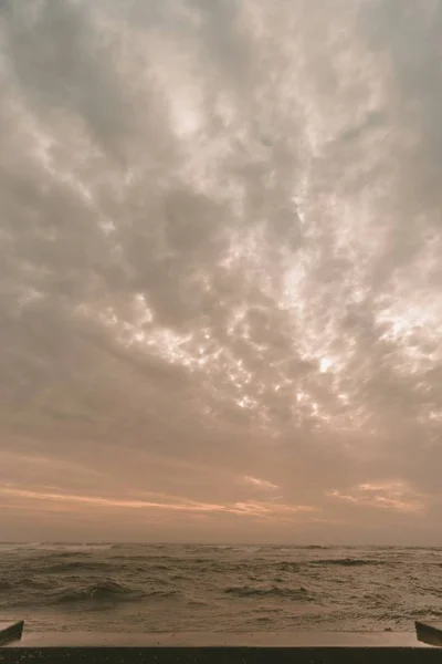 Vertical shot of the sea with waves under a cloudy sky — Stock Photo, Image