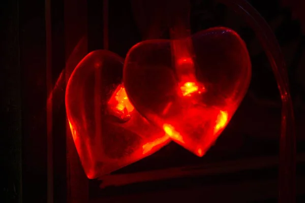 Zbliżenie Dwóch Czerwonych Serc Światłami Płonącymi Środku — Zdjęcie stockowe