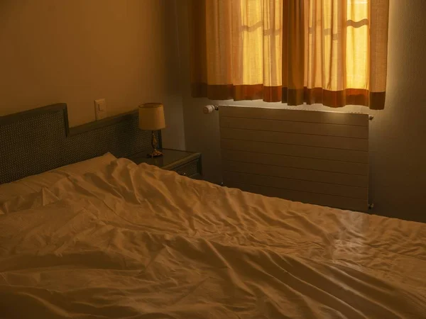 Room with the sun sliding through and shining on the wrinkly sheets — Stock Photo, Image