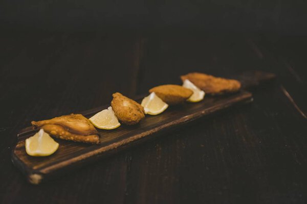 High angle shot of fried food near lemon sliced on a wooden surface Royalty Free Stock Images