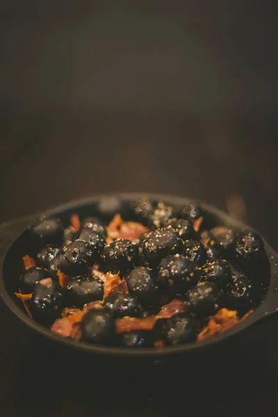 Tiro vertical de um prato lateral com azeitonas pretas em um pequeno boliche — Fotografia de Stock