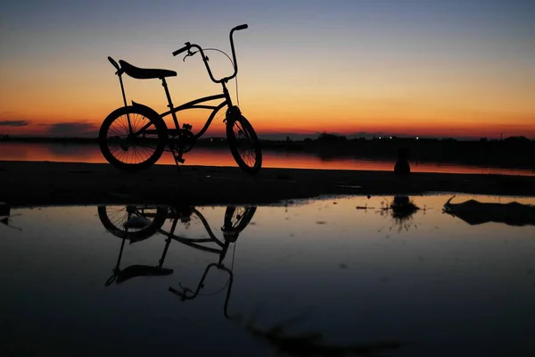 Bike silhouette in sunset sky — Stockfoto