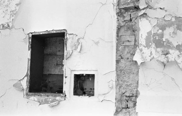 Eski bir binanın duvarındaki yıpranmış boyanın gri ölçekli görüntüsü. — Stok fotoğraf