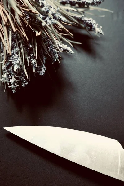 Siyah Bir Yüzeydeki Güzel Çiçeklerin Yanında Bir Bıçağın Dikey Yüksek — Stok fotoğraf