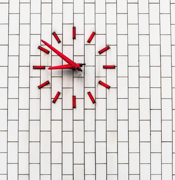 Vörös óra egy fehér téglafalon — Stock Fotó