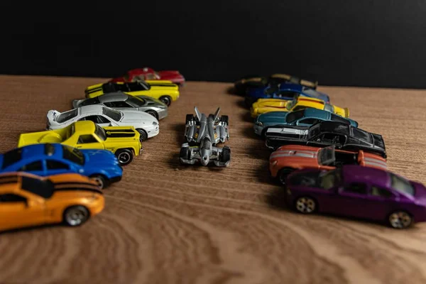 Messa a fuoco selettiva di una vettura sportiva giocattolo nel bel mezzo di altre auto giocattolo su una superficie di legno — Foto Stock