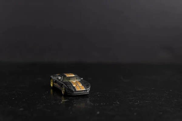 Selektywne Ujęcie Skupienia Czarnego Zabawkowego Samochodu Sportowego Żółtymi Paskami Czarnej — Zdjęcie stockowe