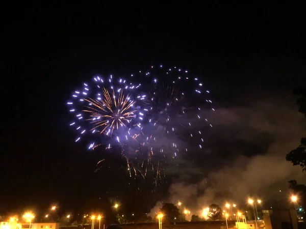 Belo fogo de artifício na cidade iluminada à noite com um fundo preto — Fotografia de Stock