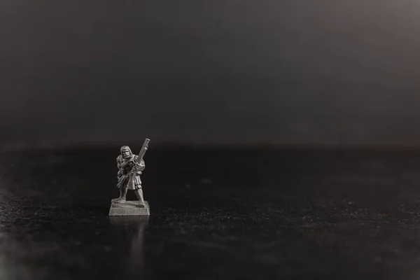 Photo sélective en niveaux de gris d'un soldat tenant une figurine d'arme à feu — Photo