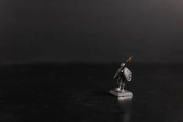Tournage sélectif en niveaux de gris d'un spartiate tenant une figurine de lance — Photo