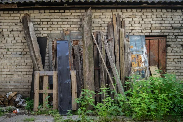 Stará kamenná stodola s dřevěnými trámy a zelení před ní — Stock fotografie