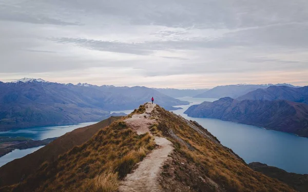 Panoramiczny widok na Roys Peak w Nowej Zelandii z niskimi górami w oddali pod chmurowym krajobrazem — Zdjęcie stockowe