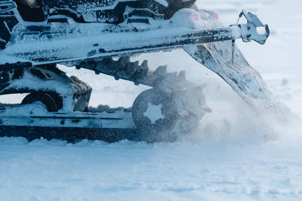 Closeup tiro das rodas de snowmobile enquanto espirra neve ao redor — Fotografia de Stock