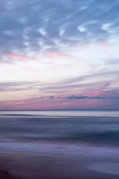 Tiro vertical do belo céu colorido sobre o mar durante o nascer do sol — Fotografia de Stock