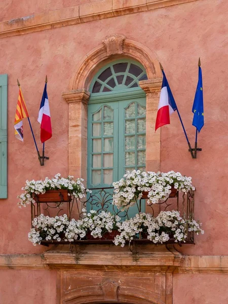 Вертикальный снимок балкона с флагами Франции, висящими на шесте — стоковое фото