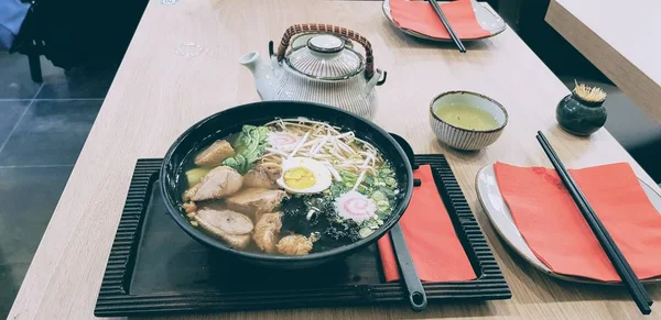 Tiro de ângulo alto de uma sopa de Ramen servida em uma tigela preta no restaurante — Fotografia de Stock