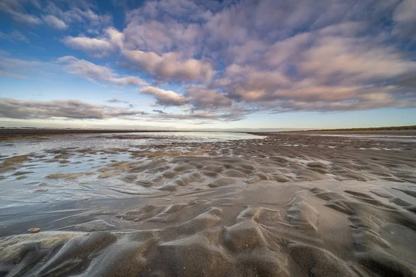 Ein Nasses Ufer Mit Kleinen Wasserpfützen Unter Blauem Bewölkten Himmel — Stockfoto