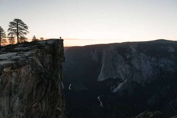 Cenário de pessoas em pé em cima de uma formação rochosa admirando a beleza da natureza — Fotografia de Stock