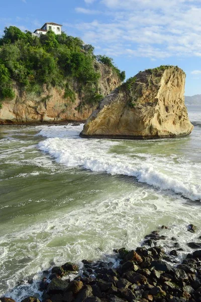 Tiro vertical de belas rochas e penhascos pelo oceano sob o céu azul — Fotografia de Stock