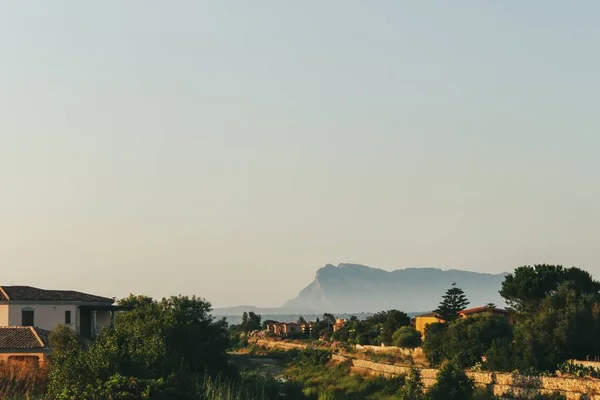 Gambar sudut tinggi dari sebuah desa di San Teodoro, Sardinia dan bukit-bukit di latar belakang — Stok Foto