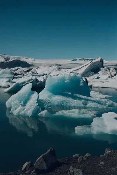 Tiro vertical dos belos icebergs sobre a água capturada na Islândia — Fotografia de Stock