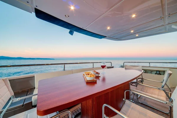 Beau cliché du yacht d'une table en bois avec verres à vin au coucher du soleil — Photo