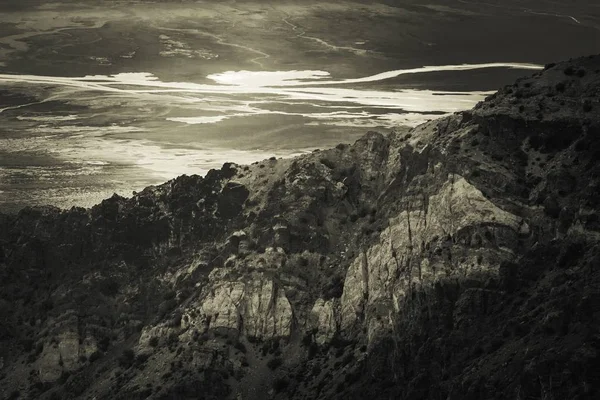 Šedivý Záběr Slunce Stoupajícího Nad Skalní Útvar Pokrytý Různými Druhy — Stock fotografie